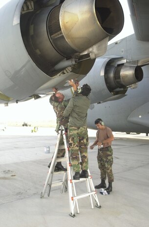 OPERATION ENDURING FREEDOM -– Senior Master Sgt. Robert Baldwin from the 437th Aircraft Generation Squadron, Master Sgt. Freddie Garcia from the 315th AGS, and Tech. Sgt. Reinaldo Rodriguez of the 437th Maintenance Squadron all at Charleston Air Force Base, S.C., make a temporary patch on a C-17A Globemaster III prior to a mission at an operating location in support of the U.S. Central Command execution of Operation Enduring Freedom. Three C-17s flew missions on Nov. 15; one dropped 17,000 humanitarian daily rations and the other two airdropped containers of blankets and wheat. (U.S. Air Force photo by Staff Sgt. Ken Bergmann) 