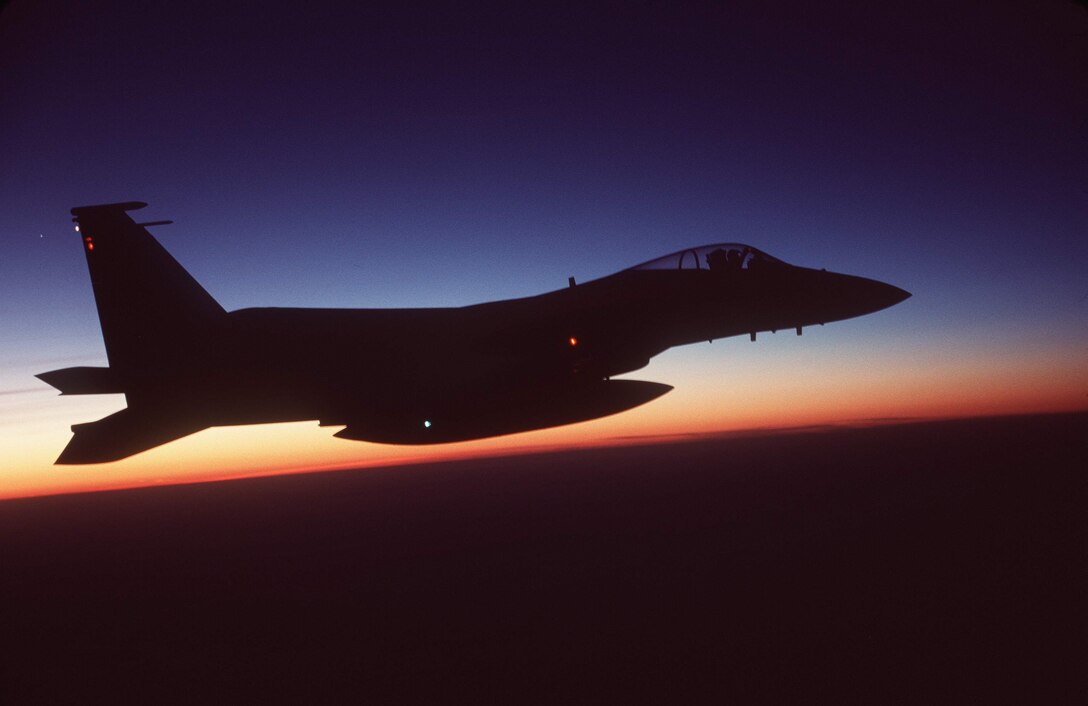 OPERATION NOBLE EAGLE -- An F-15C Eagle from the 1st Fighter Wing at Langley Air Force, Va., is silhouetted against the horizon at sunrise while performing a combat air patrol mission along the East Coast of the United States in support of Operation Noble Eagle. Nearly as many Air Force active-duty, Guard and Reserves defend American skies in Operation Noble Eagle as are deployed for Operation Enduring Freedom. (U.S. Air Force photo by Staff Sgt. Greg L. Davis)
