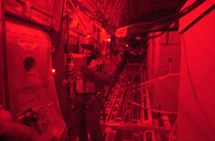 OPERATION ENDURING FREEDOM -- "Chris", a U.S. Air Force loadmaster on a C-17 Globemaster III, goes through a checklist moments before entering the drop zone. U.S. Air Force crew members from Charleston Air Force Base, S.C., continue high altitude drops of HDRs (Humanitarian Daily Rations) from their C-17 Globemaster III somewhere over Northern Afghanistan, Oct. 18. The C-17 dropped 42 TRIADS containing 17,220 HDRs.  Approximately 500,000 HDRs have been dropped into Afghanistan since the humanitarian relief effort began. (U.S. Air Force photo by Mannie Garcia/Gannett/ATPCo)