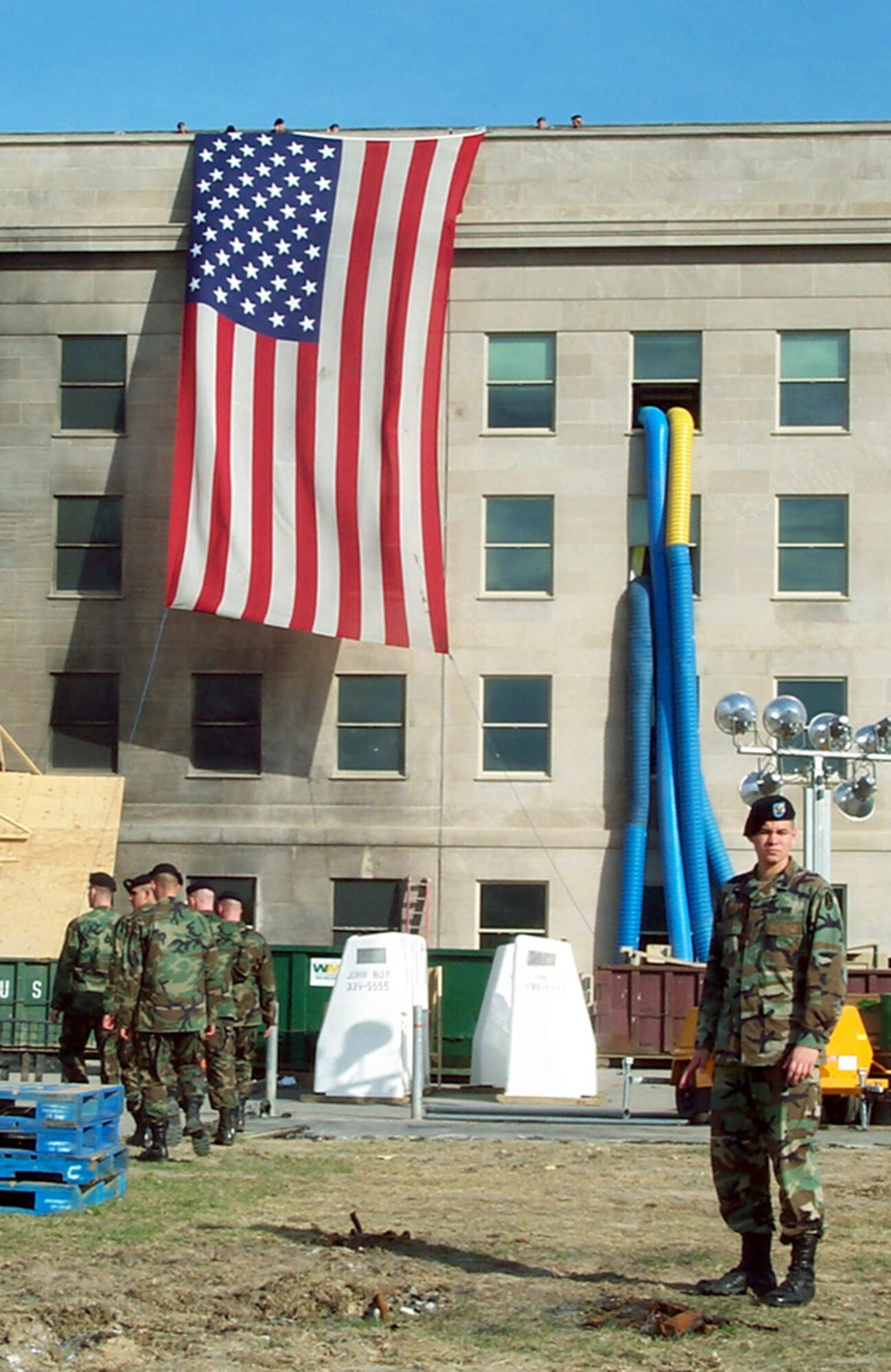WASHINGTON -- Soldiers prepare to lower the garrison flag that draped the side of the Pentagon beside the impact site where terrorists crashed a hijacked airliner Sept. 11, 2001. The soldiers lowered and folded the flag Oct. 11, 2001. (U.S. Air Force photo by Jim Garamone)

