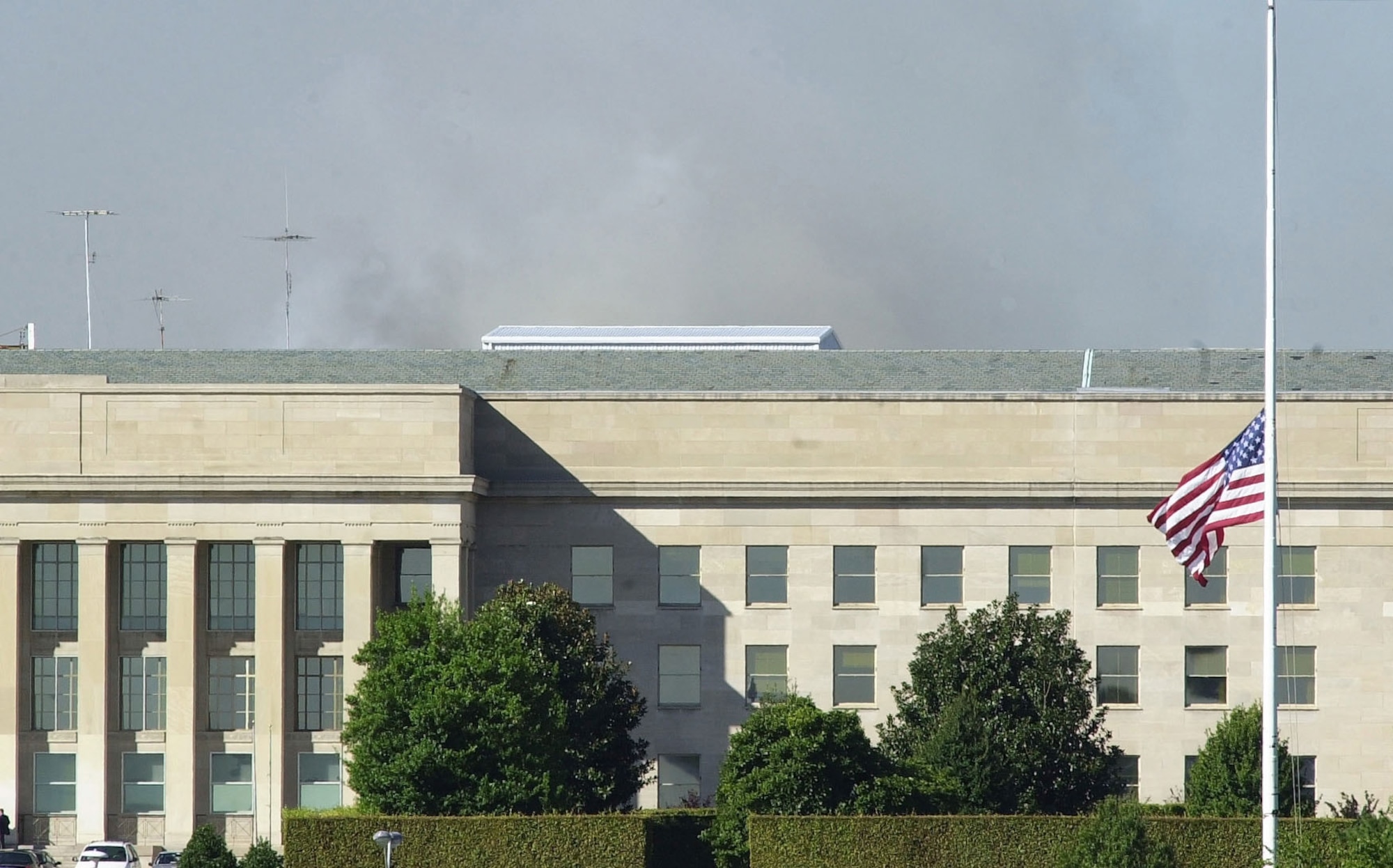 WASHINGTON -- U.S. flags flew at half-mast at the Pentagon on Sept. 12, 2001, while firefighters continued to extinguish flames after a highjacked commercial jetliner crashed into the building the day before.  The suspected terrorist attack caused extensive damage to the Pentagon and followed similar attacks on the twin towers of the World Trade Center in New York City. (U.S. Air Force photo by Tech. Sgt. Jim Varhegyi) 