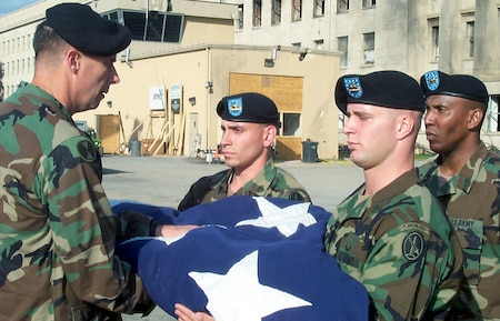 WASHINGTOM -- Soldiers from A Company, 3rd Infantry, "The Old Guard," present Military District of Washington Commander Maj. Gen. Jim Jackson with the American flag that draped the side of the Pentagon beside the impact site where terrorists crashed a hijacked airliner Sept. 11, 2001. The soldiers lowered and folded the flag Oct. 11, 2001. (U.S. Air Force photo by Jim Garamone)

