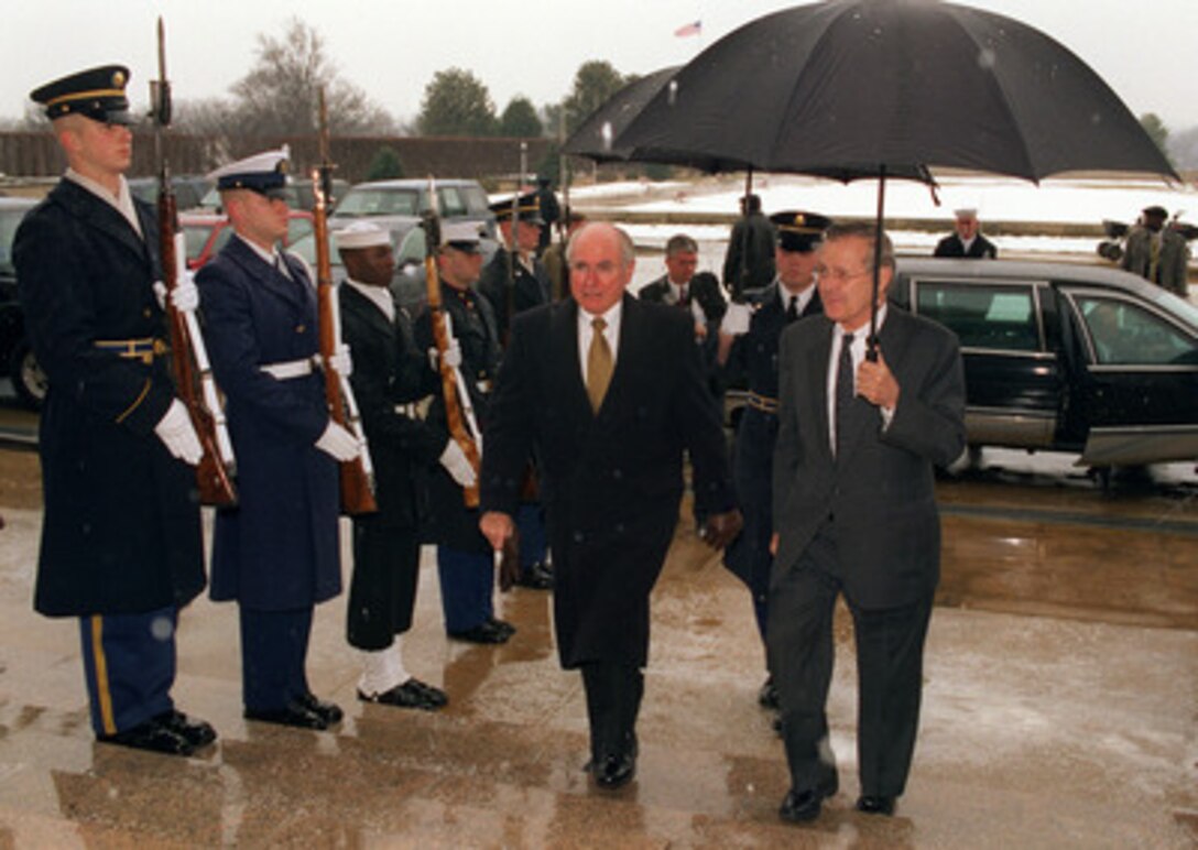 Secretary of Defense Donald H. Rumsfeld (right) escorts Australian Prime Minister John Howard through an honor cordon and into the Pentagon on Feb. 10, 2003. Rumsfeld and Howard will meet to discuss a range of bilateral security issues including the situation in Iraq. 