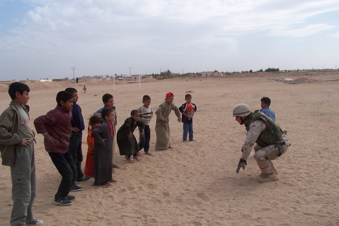 SHAMAR VILLAGE, Iraq ? Steelworker 3rd Class David Blish conducts daily calisthenics sessions with children. Blish is a Tactical Movement Team convoy driver. Convoy troops have established first name basis friendships with the local children who come out to the project every day.