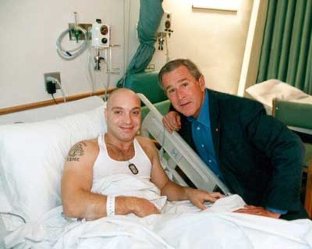President George W. Bush poses for a photo at Bethesda Naval Medical Center with Alex Presman (left) Aug 2, 2003, which was Presman's 25th birthday.  Presman, who was a Corporal at the time, received a Purple Heart from the Commandant of the Marine Corps that same day.