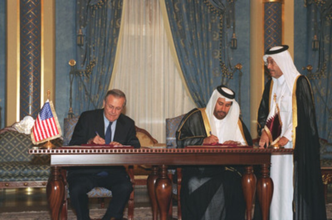 Secretary of Defense Donald H. Rumsfeld (left) and Minister of Foreign Affairs Hamad bin Jasim Al-Thani sign an implementation agreement in Wabah Palace in Doha, Qatar, on Dec. 11, 2002. The agreement will improve readiness, provide state-of-the-art military capabilities for forces in the country and permit a variety of quality-of-life upgrades to facilities in the Persian Gulf nation. Rumsfeld traveled to Qatar and countries in the Horn of Africa to meet with local leaders and U.S. personnel deployed there. 