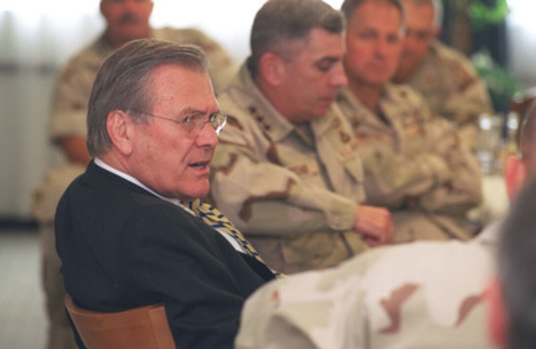 Secretary of Defense Donald H. Rumsfeld conducts a working luncheon with Commander Central Command Gen. Tommy Franks, U.S. Army, and his staff assembled at As Sayliyah Military Camp, Qatar, on Dec. 12, 2002. Rumsfeld is in Qatar to meet with U.S. personnel at the Central Command forward headquarters and its supporting units. 