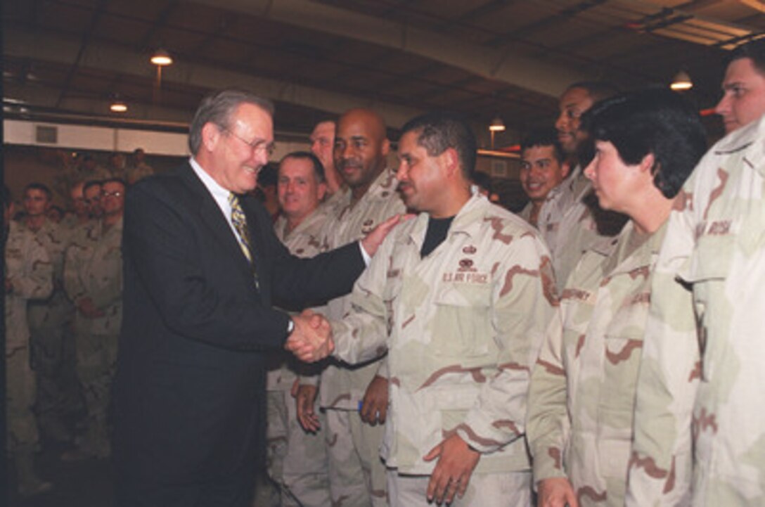 Secretary of Defense Donald H. Rumsfeld shakes hands with troops following a town hall meeting at As Sayliyah Military Camp, Qatar, on Dec. 12, 2002. Rumsfeld is in Qatar to meet with U.S. personnel at the Central Command forward headquarters and its supporting units. 