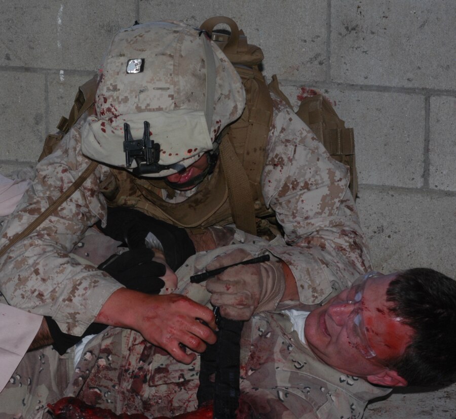 Cpl. Robert Nevers, a Toledo, Ohio native, wraps a tourniquet around the arm of a wounded role player May 24 at the 25 Area Combat Town, Camp Pendleton, Ca.. Marines from 1st Platoon, Company L, 3rd Battalion, 25th Marine Regiment participated in a combat trauma class as part of their training.