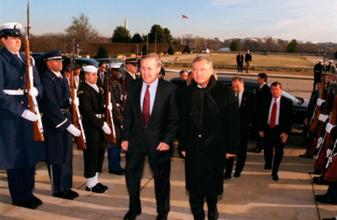 Secretary of Defense Donald H. Rumsfeld (left) escorts Polish President Aleksander Kwasniewski (right) into the Pentagon on Jan. 14, 2003. Rumsfeld and Kwasniewski will meet for bilateral security discussions. 