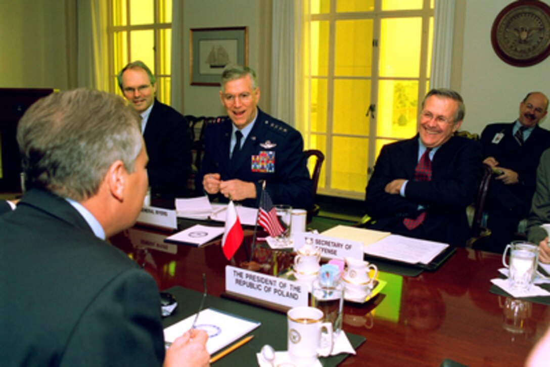 Secretary of Defense Donald H. Rumsfeld (right) shares a light moment with Polish President Aleksander Kwasniewski (foreground) at the beginning of their meeting in the Pentagon on Jan. 14, 2003. U.S. Ambassador to Poland Christopher R. Hill (left) and Chairman of the Joint Chiefs of Staff Gen. Richard B. Myers (center), U.S. Air Force, joined Rumsfeld and Kwasniewski to discuss a range of bilateral security issues. 