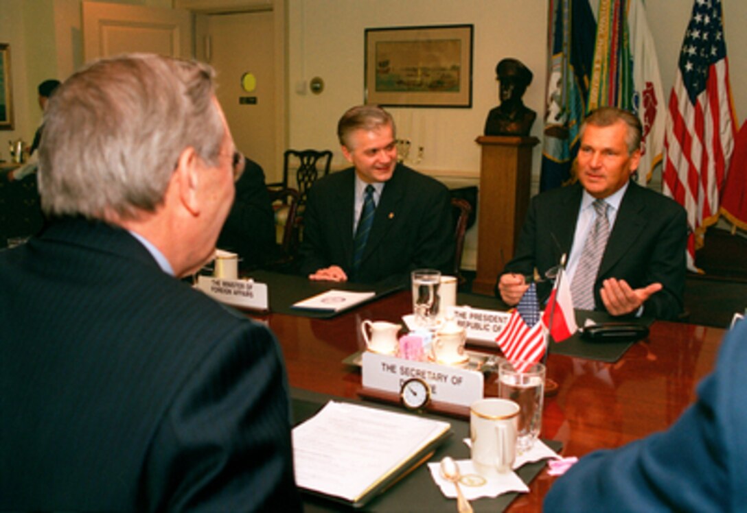 Polish President Aleksander Kwasniewski (right) meets with Secretary of Defense Donald H. Rumsfeld (foreground) in the Pentagon on Jan. 14, 2003. Foreign Minister Wlodzimierz Cimoszewicz (center) joined Kwasniewski and Rumsfeld to discuss a range of bilateral security issues. 