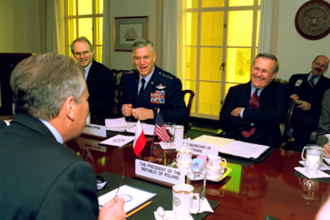 Secretary of Defense Donald H. Rumsfeld (right) shares a light moment with Polish President Aleksander Kwasniewski (foreground) at the beginning of their meeting in the Pentagon on Jan. 14, 2003. U.S. Ambassador to Poland Christopher R. Hill (left) and Chairman of the Joint Chiefs of Staff Gen. Richard B. Myers (center), U.S. Air Force, joined Rumsfeld and Kwasniewski to discuss a range of bilateral security issues. 