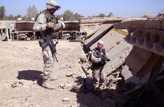BAGHDAD, Iraq -- Staff Sgt. Tony Newbern (left) and Master Sgt. Eddy Dominguez find unexploded ordnance imbedded in the roof of a building.  Despite the presence of the ordnance at the assessment site, Combined Weapons Effectiveness Assessment Team members continued their evaluation.  Newbern and Dominguez are explosive ordnance disposal specialists deployed to Iraq from Charleston Air Force Base, S.C.  (U.S. Air Force photo by Capt. Roger Burdette)