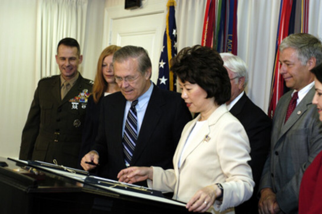 Secretary of Defense Donald H. Rumsfeld and Secretary of Labor Elaine L. Chao sign a memorandum of understanding on July 11, 2003, at the Pentagon that will ease re-entry into the civilian workforce by military personnel. The memorandum will strengthen Department of Labor efforts to support returning reservists' job search, expand American's Job Bank to include recruiting for military jobs, expand Department of Labor employment infrastructures to support employment of military spouses, and encourage corporate America to hire returning reservists and military spouses. From left to right: Vice Chairman, Joint Chiefs of Staff Gen. Peter Pace, USMC; military spouse Ms. Lisa Clay; Rumsfeld; Chao; Congressman Michael Michaud (D-ME). 