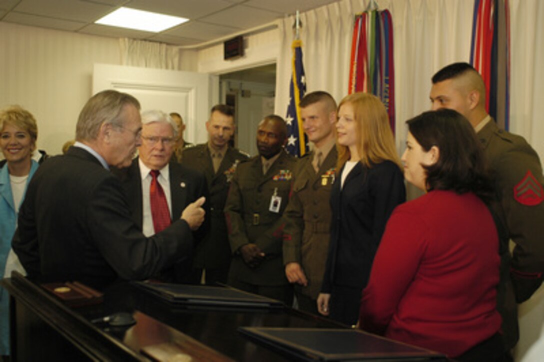 Secretary of Defense Donald H. Rumsfeld stresses the importance of the memorandum of understanding he just signed with Department of Labor Secretary Elaine L. Chao. The document signed on July 11, 2003, in the Pentagon will ease re-entry into the civilian workforce by military personnel. The memorandum will strengthen Department of Labor efforts to support returning reservists' job search, expand American's Job Bank to include recruiting for military jobs, expand Department of Labor employment infrastructures to support employment of military spouses, and encourage corporate America to hire returning reservists and military spouses. From left to right, Rumsfeld; Congressman Henry E. Brown, Jr. (R-SC); Vice Chairman, Joint Chiefs of Staff Gen. Peter Pace, USMC; Sergeant Major of the Marine Corps John L. Estrada; Sergeant Daniel Clay, USMC; Mrs. Lisa Clay, spouse of Sergeant Clay; Mrs. Ilka Regino, spouse of Corporal Paul Regino (obscured). 
