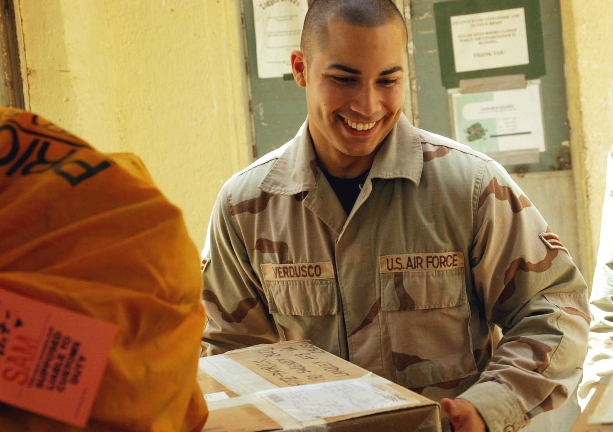 TALLIL AIR BASE, Iraq -- Airman 1st Class Gary Verdusco helps keep packages moving to airmen stationed here.  Mail is delivered daily to the Air Force's post office, and a 10-person team works seven days a week to make sure letters and packages get to their intended recipients.  Verdusco is a postal finance clerk assigned to the 407th Expeditionary Communication Squadron.  (U.S. Air Force photo by 2nd Lt. Gerardo Gonzalez)