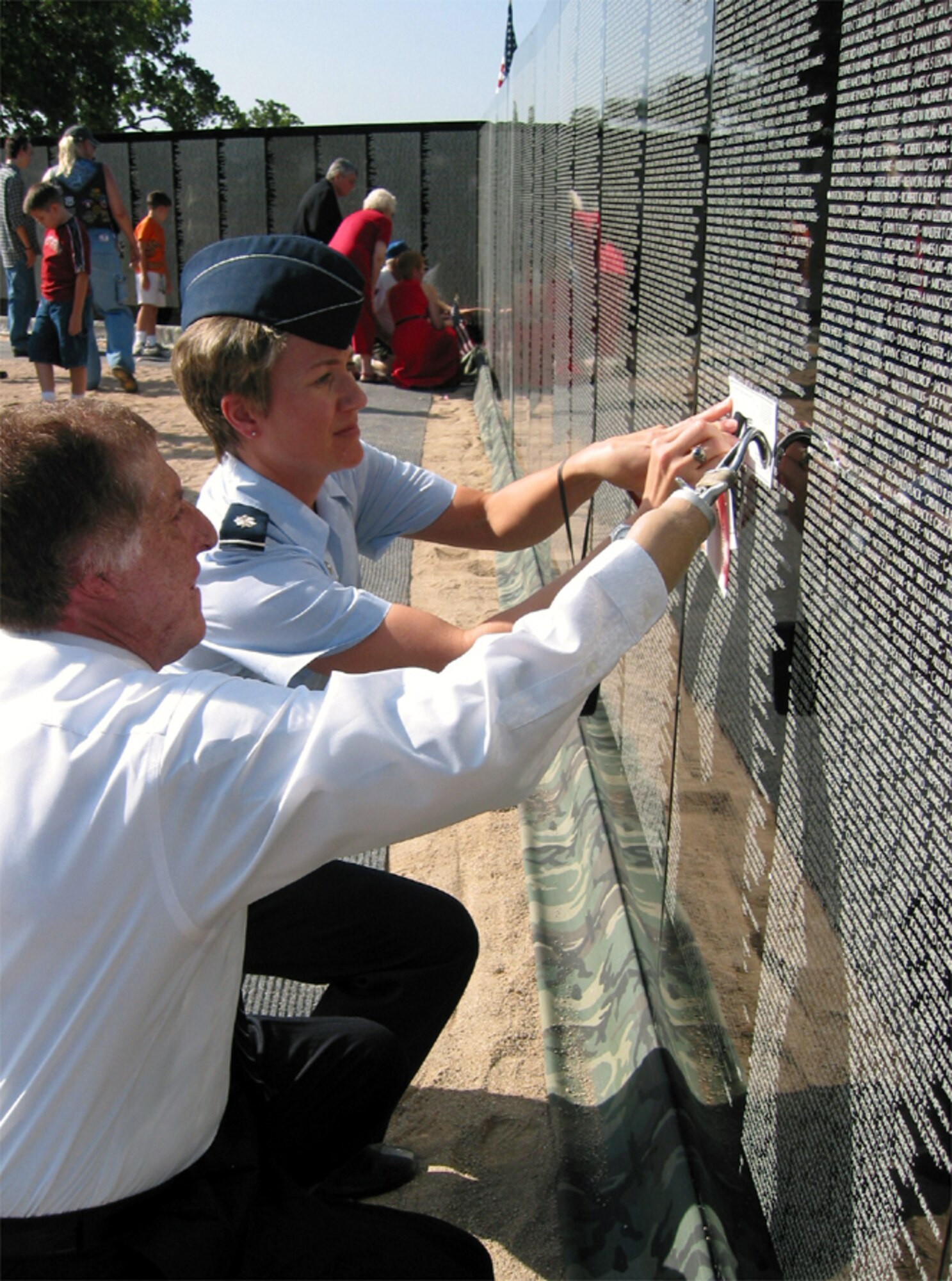 KERRVILLE, Texas -- Lt. Col. Jennifer Graham and Roberto Barrera take an impression of her father's name from the Vietnam Moving Wall Memorial here.  Graham is the 47th Mission Support Squadron commander at Laughlin Air Force Base, Texas.  Barrera is flight chief of the base's family support center.  (U.S. Air Force photo by Capt. Paula Kurtz)