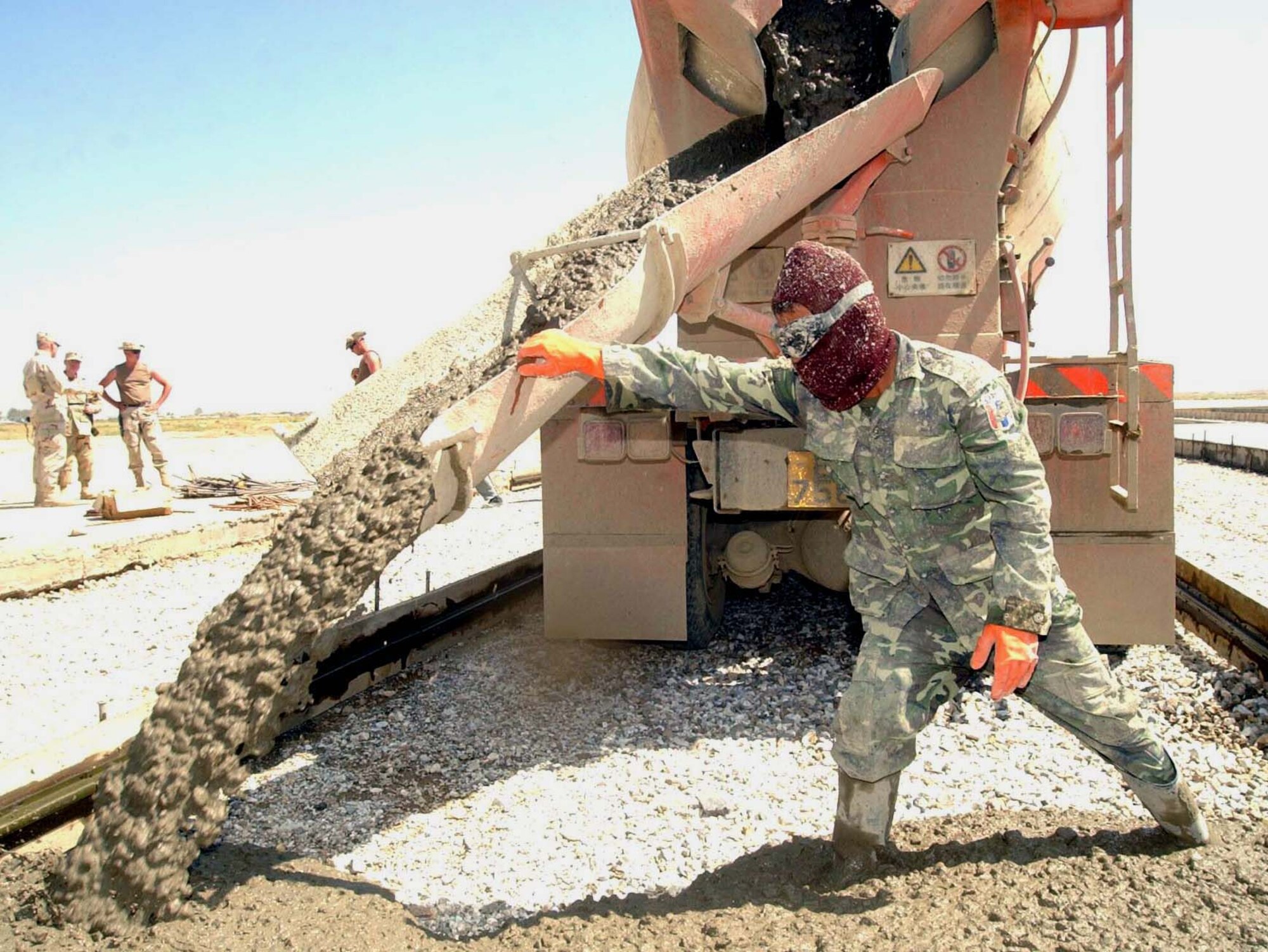 BAGRAM AIR BASE, Afghanistan -- A member from the Thai military pours concrete into a form for the reconstruction of the runway here. The project is funded by the Army and coordinated by the 455th Civil Engineer Squadron.  (U.S. Air Force photo by Staff Sgt. Russell Wicke)