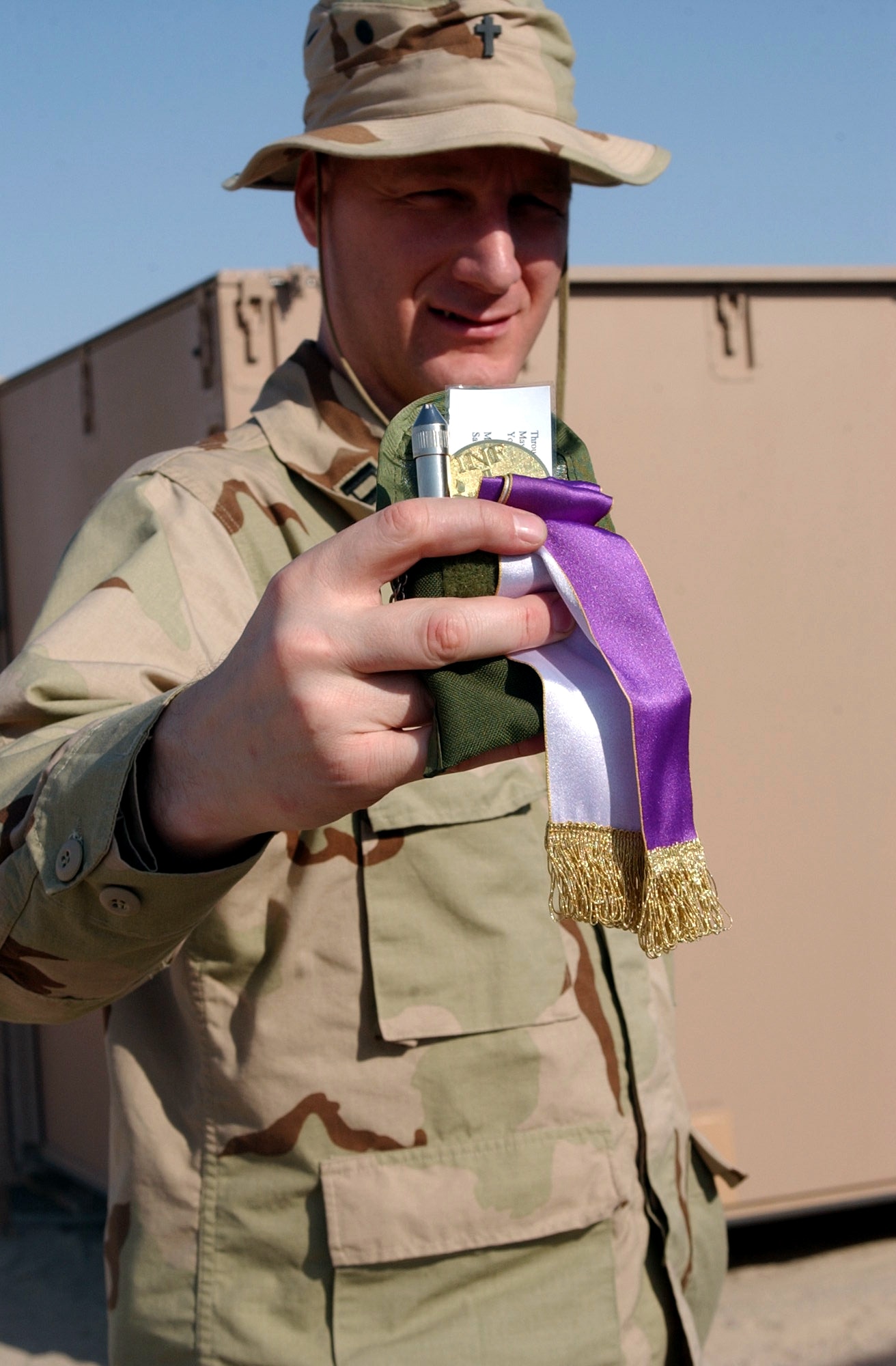 TALLIL AIR BASE, Iraq -- Chaplain (Capt.) Eugene Theisen holds the tools of his trade.  As a Catholic priest and member of the 407th Air Expeditionary Group chapel staff, Theisen carries with him at all times a vial of holy water for blessings, a stole for hearing confessions and holy oil for anointing the sick, hurt or injured.  He is deployed as part of the 332nd Air Expeditionary Wing supporting Operation Iraqi Freedom.  (U.S. Air Force photo by 2nd Lt. Gerardo Gonzalez)