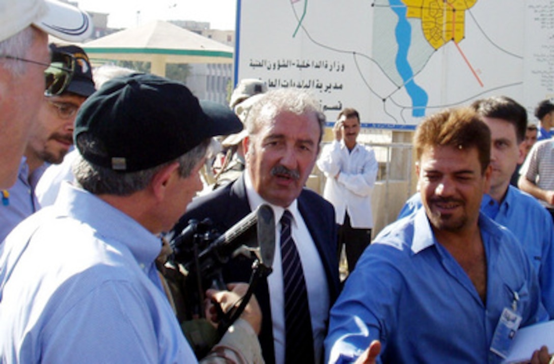 Deputy Secretary of Defense Paul Wolfowitz (left) is greeted by Iraqi citizens as he walks through the streets of Mosul, Iraq, on July 21, 2003. Wolfowitz talked to Iraqi citizens in the streets and met with the town council during his visit to Mosul. Wolfowitz is in Iraq to meet with the senior military and civilian leadership and deployed troops. 