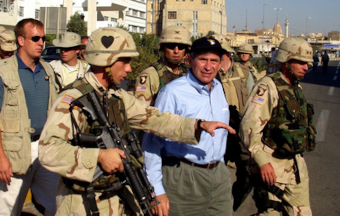 Deputy Secretary of Defense Paul Wolfowitz (center) is escorted by Army Gen. David H. Petraeus (right), commander, 101st Airborne Division, as they walk through the streets of Mosul, Iraq, on July 21, 2003. Wolfowitz talked to Iraqi citizens in the streets and met with the town council during his visit to Mosul. Wolfowitz is in Iraq to meet with the senior military and civilian leadership and deployed troops. 