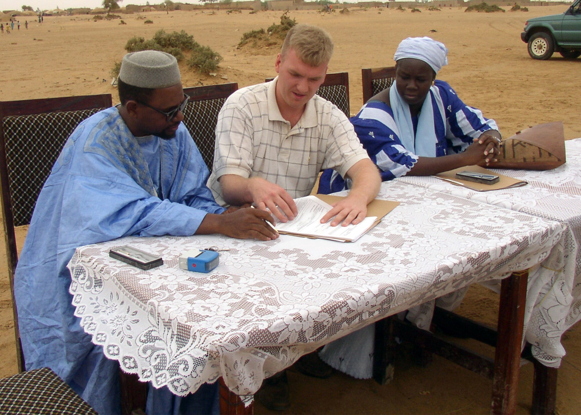 GAO, Mali -- Tech. Sgt. Brad Smith finalizes a contract with two Mali representatives.  Smith recently traveled here to sign more than $430,000 in contracts earmarked for humanitarian projects.  He is a contracting officer assigned to the 39th Contracting Squadron at Incirlik Air Base, Turkey. (U.S. Air Force photo by Maj. Michael Marzec)