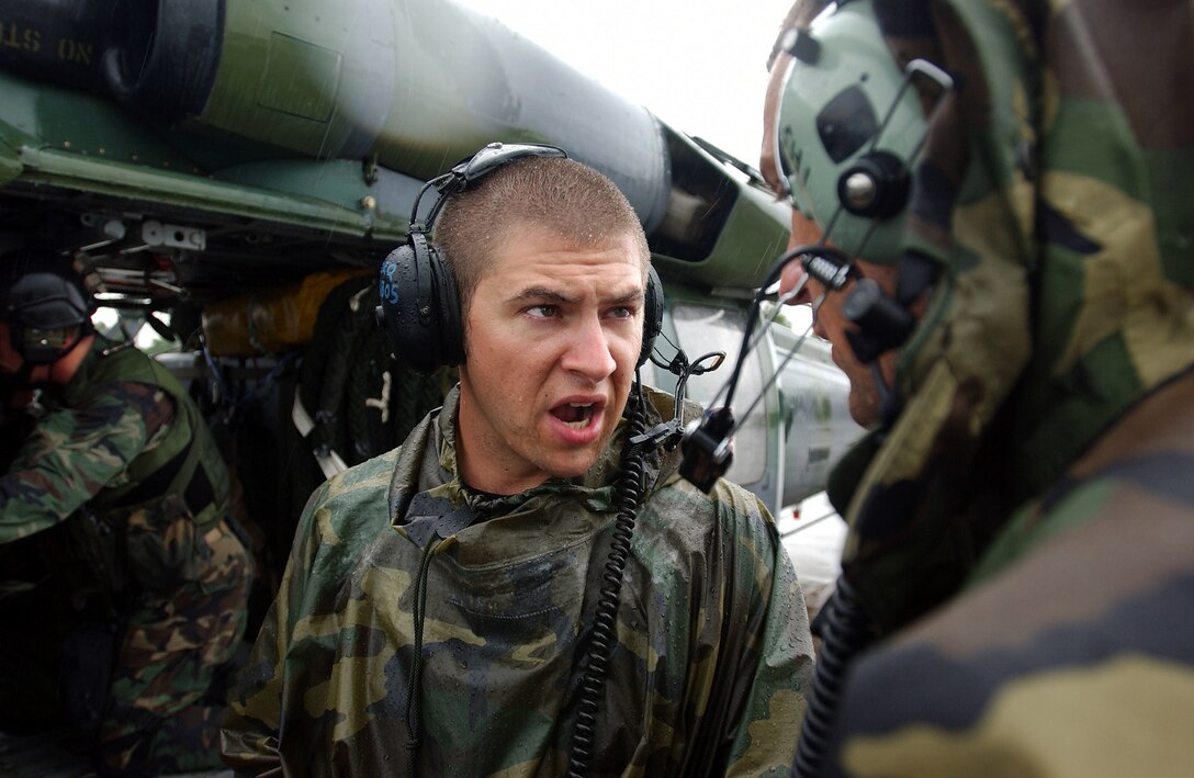 LUNGI, Sierra Leone -- Staff Sgt. Jason Krokos speaks with other maintainers here July 24 while Marines load onto HH-60G Pave Hawk helicopters.  The Marines are part of the Fleet Antiterrorism Security Team from U.S. Naval Air Station Rota, Spain.  The 398th Air Expeditionary Group's helicopters and airmen provide personnel recovery and emergency evacuation capability for the Marines and the humanitarian assistance survey team in Liberia.  Krokos is a crew chief with the 85th Maintenance Squadron deployed from Naval Air Station Keflavik, Iceland.  (U.S. Air Force photo by Tech. Sgt. Justin D. Pyle)