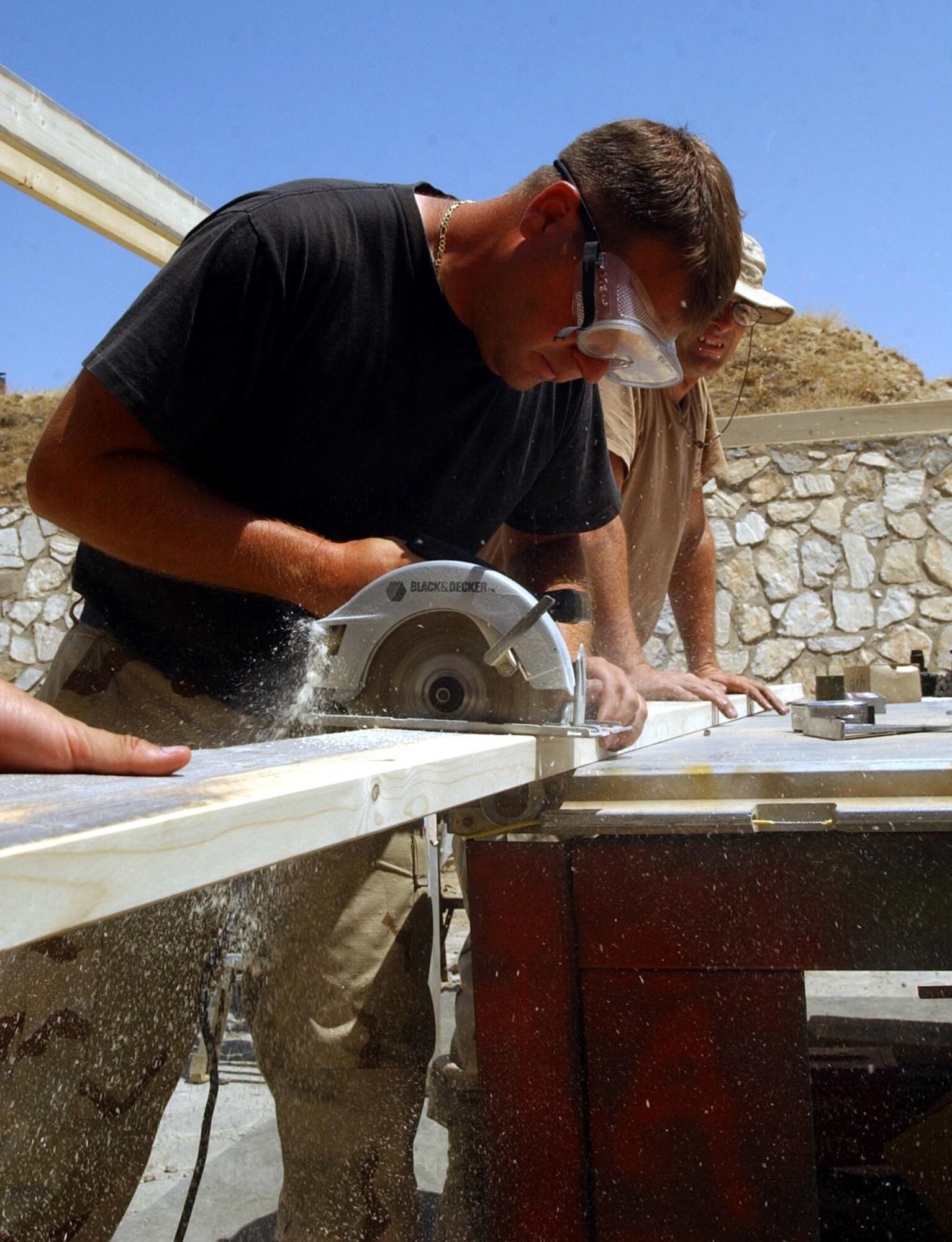 BAGRAM AIR BASE, Afghanistan -- Staff Sgt. Eric Krueger cuts a plank for a shelter to shade the work area here where his team builds munitions.  Krueger is munitions troop with the 81st Expeditionary Fighter Squadron's ammunitions flight.  (U.S. Air Force photo by Staff Sgt. Russell Wicke)