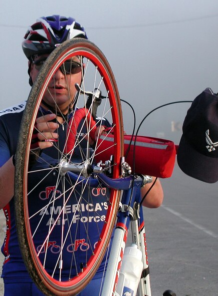 WESTERN IOWA -- Tech. Sgt. Dennis Wermers checks his front-wheel spokes on the road to Shenandoah, Iowa.  Wermers is stationed at Offut Air Force Base, Neb.  He joined 90 other Air Force cyclists for the 450-mile, seven-day Des Moines Register's Annual Great Bike Ride Across Iowa.  (U.S. Air Force photo by Cynthia Bauer)