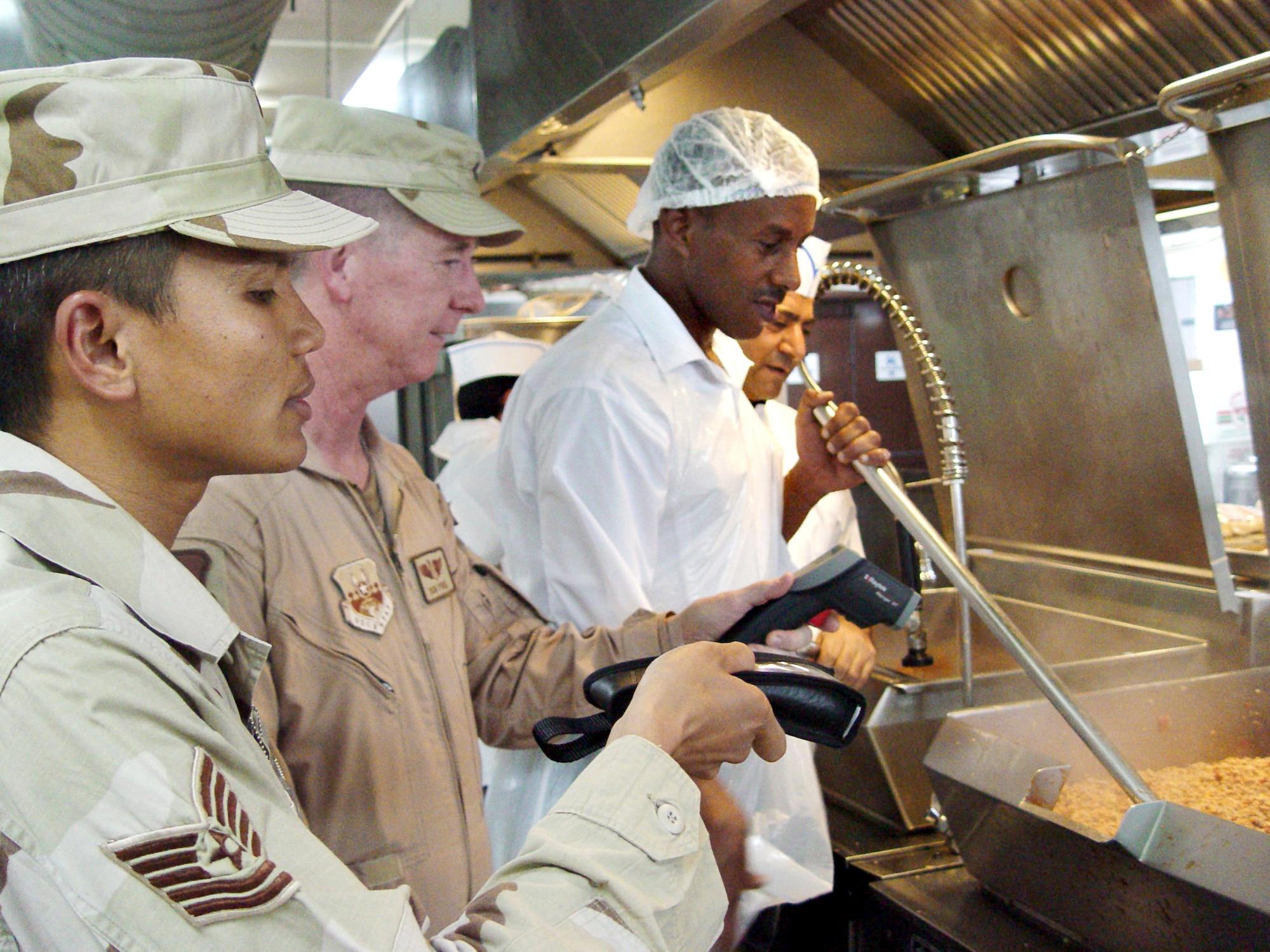 OPERATION ENDURING FREEDOM -- Tech. Sgt. Henry Reyes (left) and Lt. Col. Ron Poole check the temperature of the food being cooked at a forward-deployed location's dining facility as part of a public health routine kitchen inspection.  (U.S. Air Force Photo by Senior Airman Rachel Bush)