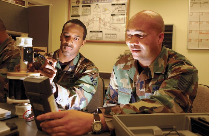CHARLESTON AIR FORCE BASE, S.C. -- Airman 1st Class Antonio Gault (left) and Master Sgt. Lyndon Dallas check a compensator probe, which helps determine how much fuel is in an aircraft fuel tank.  Aircraft fuels systems specialists here teamed with Boeing engineers to fix a probe problem that emerged early during Operation Enduring Freedom.  The team developed procedures to remove and clean the probes, saving taxpayers the approximately $844,000 it would have cost to replace all four probes on every C-17 Globemaster III in the fleet.  Gault and Dallas are assigned to the 437th Maintenance Squadron here.  (U.S. Air Force photo by Airman 1st Class Jason Bailey)