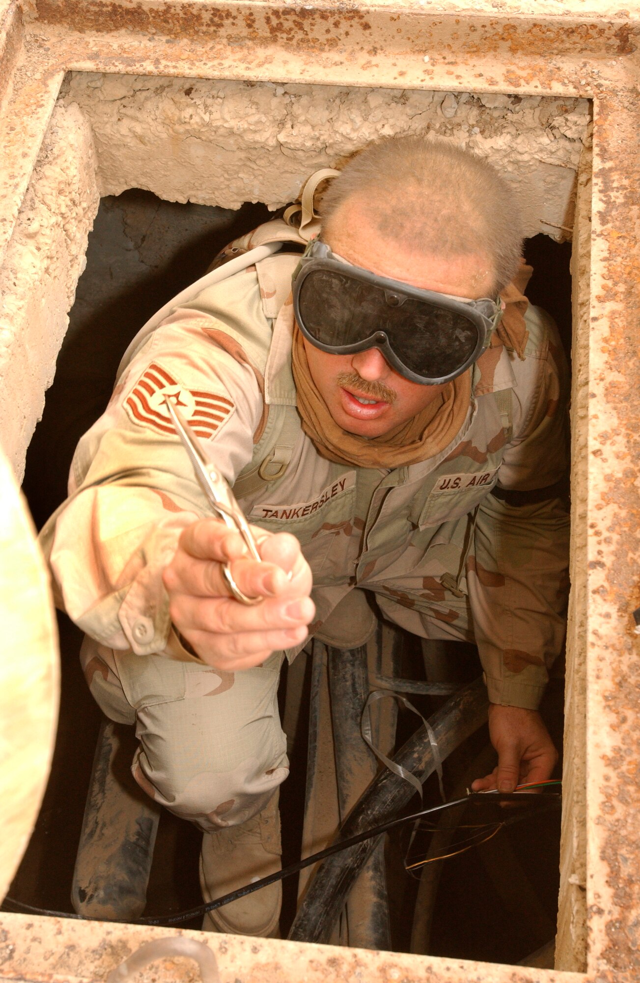 OPERATION IRAQI FREEDOM (AFPN) -- Tech. Sgt. Denny Tankersley prepares to splice fiber-optic cable at Tallil Air Base in southern Iraq. Tankersley is assigned to the 5th Combat Communications Group from Robins Air Force Base, Ga. (U.S. Air Force photo by Master Sgt. Terry L. Blevins.)