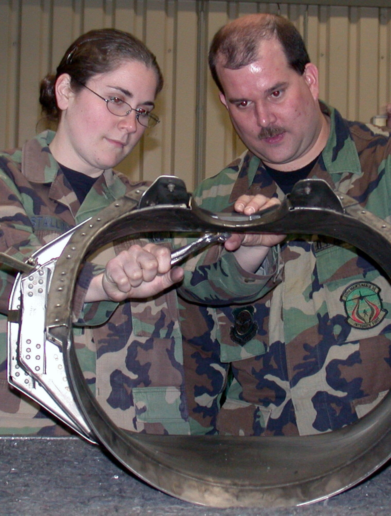 RAMSTEIN AIR BASE, Germany -- Senior Airman Sarah Stallings rivets an inlet ring for a C-130 Hercules aircraft while Tech. Sgt. Scott Obermiyer watches.  Stallings is assigned to the 86th Maintenance Squadron.  Obermiyer is from the 910th Airlift Wing and assigned to the 38th Airlift Squadron (Provisional) while here.  (U.S. Air Force photo by Tech. Sgt. Caryn Gardenhire)