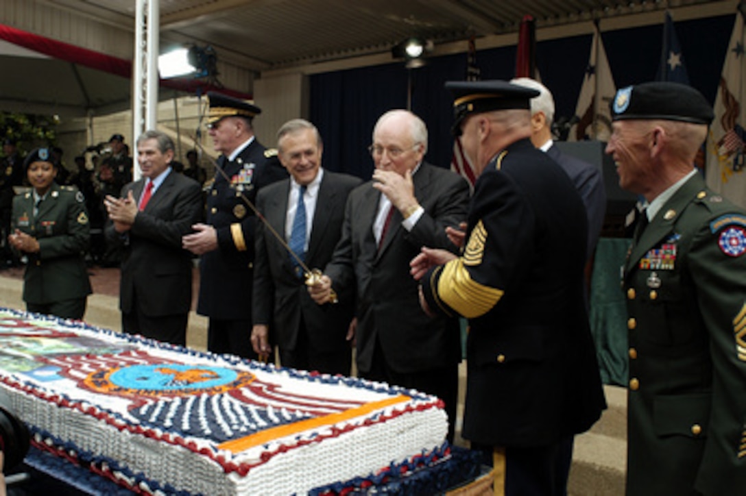 Vice President Dick Cheney gets a taste of the frosting after cutting a cake during a ceremony commemorating the Army's 228th birthday at the Pentagon on June 13, 2003. Joining Cheney in the ceremony are from left to right: Pfc. Brandie Stringer, 66th Military Police Company; Deputy Secretary of Defense Paul Wolfowitz, Vice Chief of Staff U.S. Army Gen. John M. Keane; Secretary of Defense Donald H. Rumsfeld, Cheney, Acting Secretary of the Army Les Brownlee (obscured), Sgt. Maj. of the Army Jack L. Tilley, Master Sgt. David Mitchell, Department of Defense Criminal Investigation Task Force. 