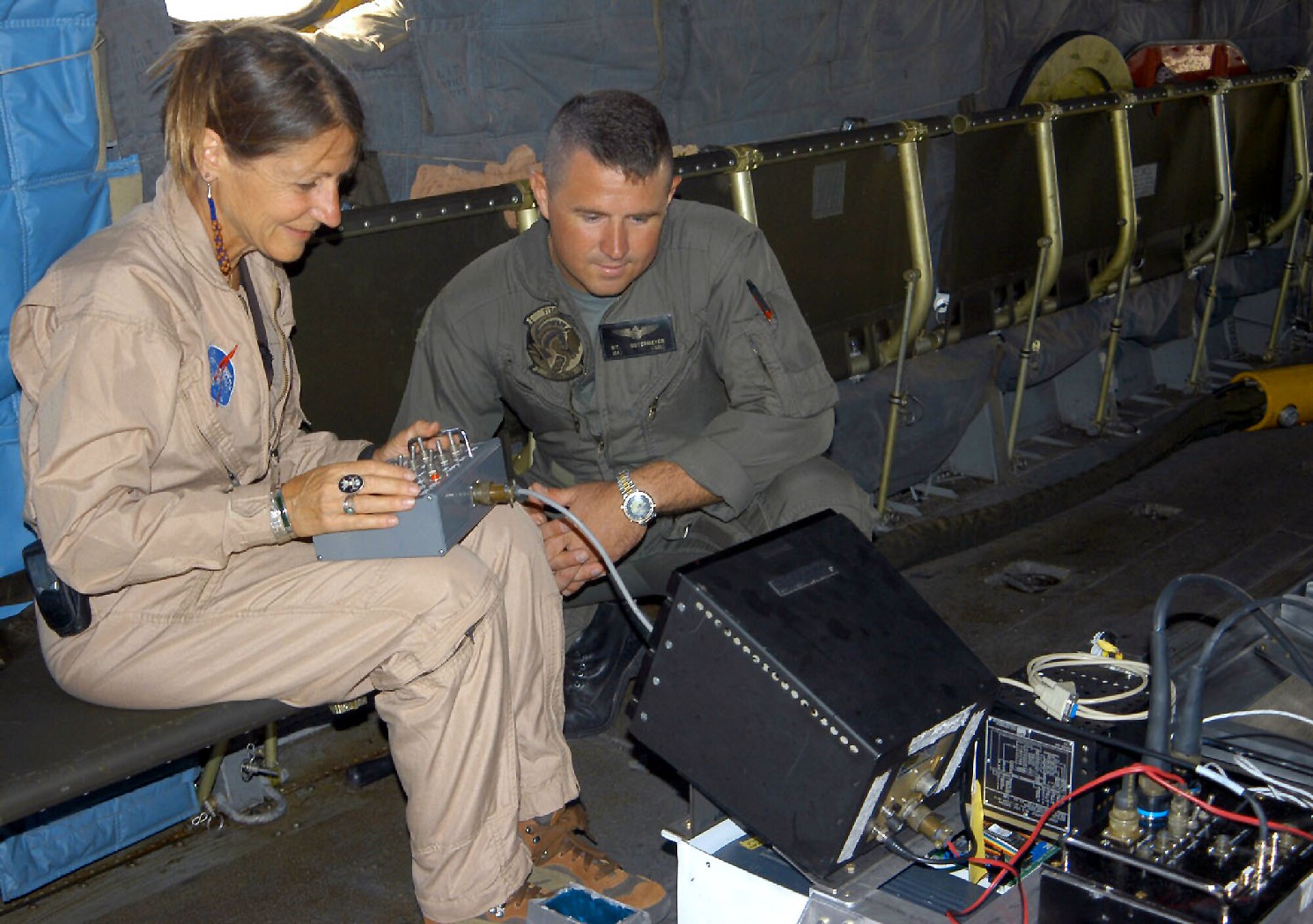 EDWARDS AIR FORCE BASE, Calif. -- Jeannette van den Bosch (left) and Marine Maj. Rick Ostermeyer check radar equipment.  Officials from the NASA Dryden Flight Research Center, Marine Heavy Helicopter Squadron 769 and the base's environmental management directorate are working to detect hazardous-waste sites.  Van den Bosch is a NASA Airborne Science Facility sensor manager, and Ostermeyer is a CH-53E helicopter pilot.  (U.S. Air Force photo by Airman 1st Class Wes Auldridge)