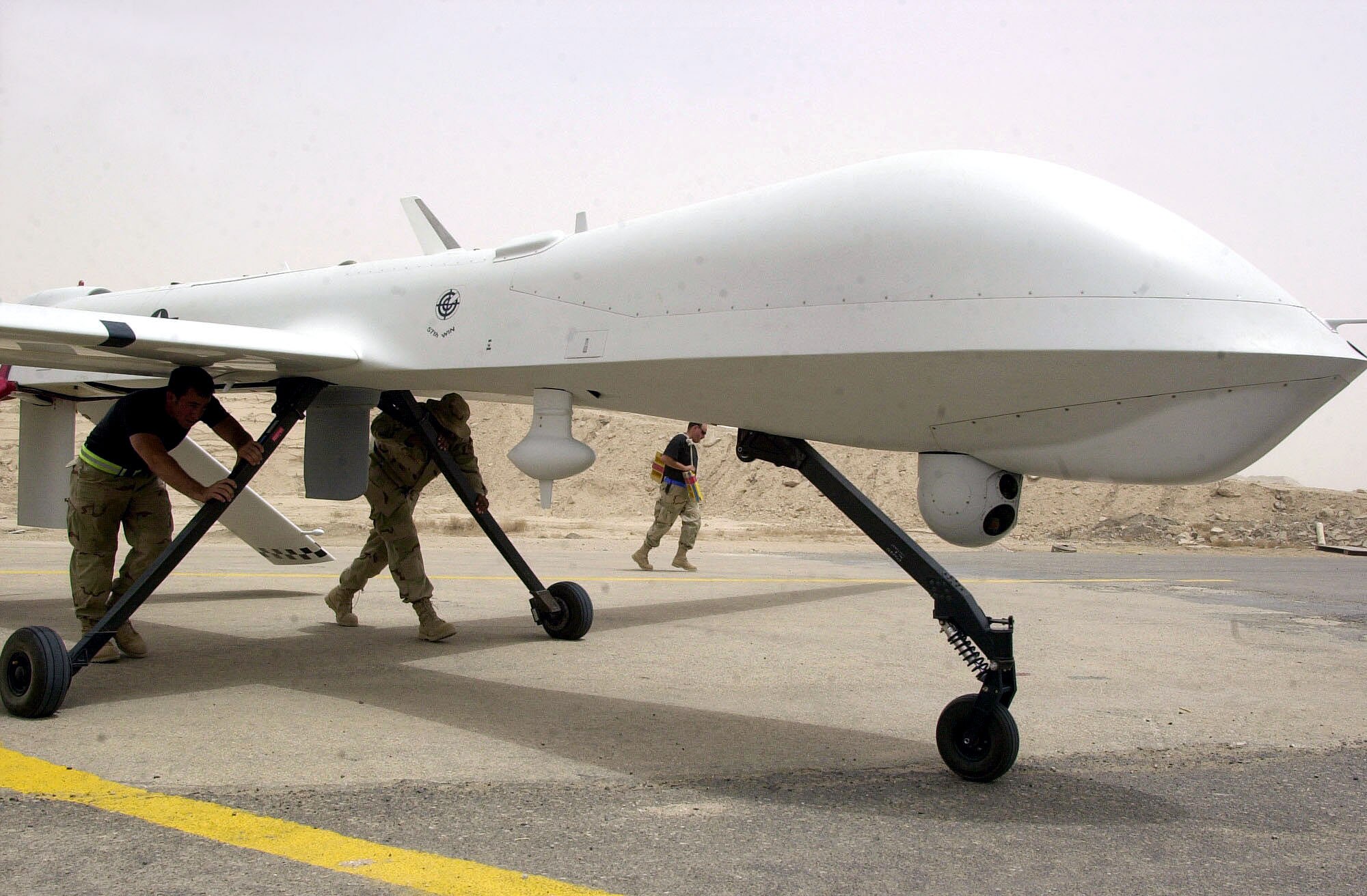 TALLIL AIR BASE, Iraq -- Airmen from the 64th Expeditionary Reconnaissance Squadron position a Predator unmanned aerial vehicle.  The Predator is a complete system, not just an individual airframe.  A fully operational system consists of four Predator units, a ground-control station, a satellite link and about 55 people to support continuous 24-hour operations.  (U.S. Air Force photo by Master Sgt. Deb Smith)