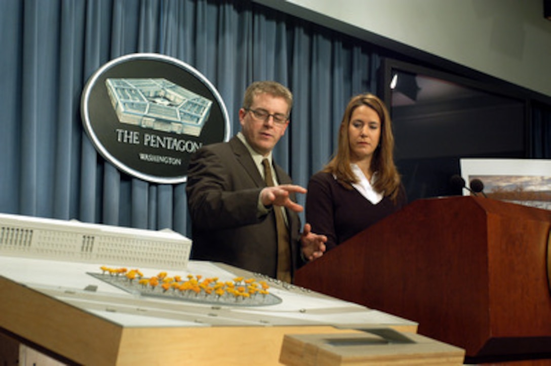 Keith Kaseman (left) and Julie Beckman explain the winning design of the Pentagon Memorial, called "Light Benches", to reporters at a Pentagon press conference on March 3, 2003. The memorial will be built on a 1.93-acre plot on the Pentagon reservation near the spot where the Sept. 11, 2001, terrorist attack occurred on the building. The memorial encompasses the entire memorial site and includes 184 benches with the name of each victim engraved into the face of the bench. The benches are to be comprised of cast, clear, anodized aluminum polyester composite matrix set on an eight-inch concrete pad for stabilization. Each bench will be positioned according to the age of the victim, progressing from the youngest, age 3, to the oldest, age 71. Each memorial bench will have a glowing light pool set underneath. The site also will have clusters of trees throughout to provide shading and a more intimate atmosphere. The estimated cost to build the memorial is between $4.9 million and $7.4 million. Taxpayer funds will not be used for the construction of this project. 
