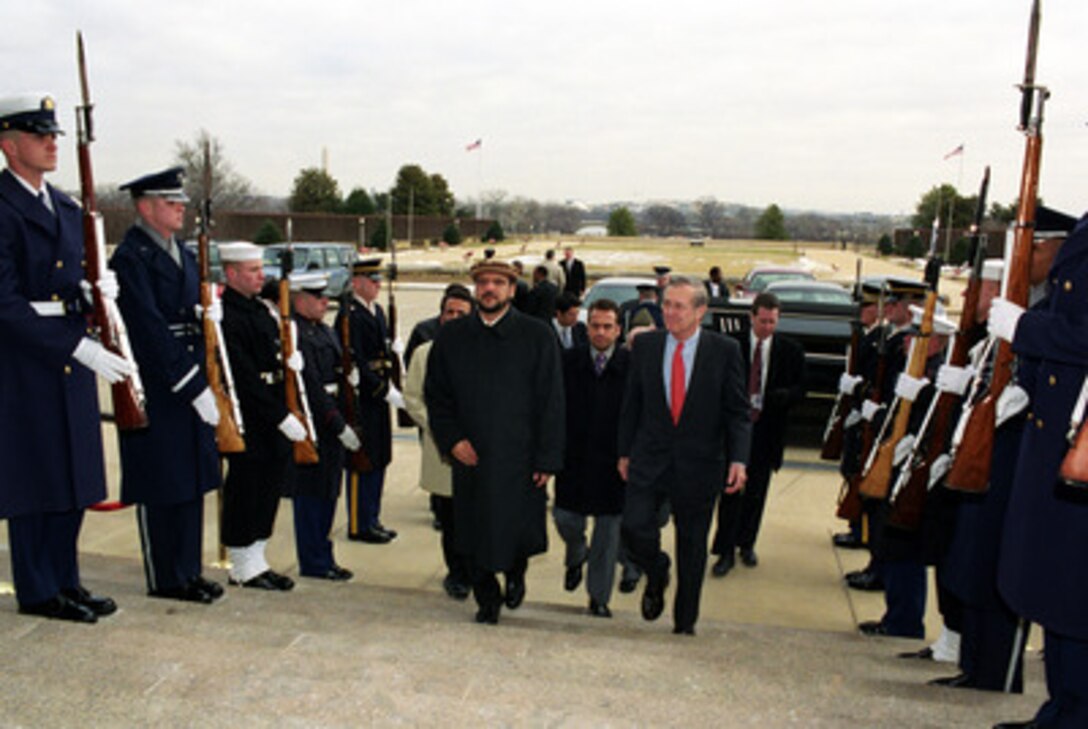 Secretary of Defense Donald H. Rumsfeld (right) escorts Afghanistan's Vice President and Minister of Defense Mohammad Fahim Khan (left) through an honor cordon and into the Pentagon on March 4, 2003. Rumsfeld and Khan will meet to discuss defense issues of mutual interest and the future of Afghanistan. 