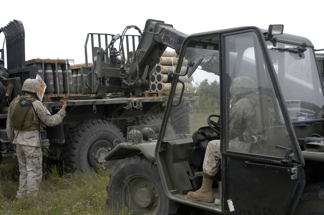 Lance Cpl Brandon Clowdus, a Reserve Marine heavy-equipment operator with Headquarters Battery, 14th Marine Regiment based in Fort Worth, Texas, operates a 5K Terex construction vehicle June 10 to unload artillery rounds from a 7-ton truck with the assistance of Gunnery Sgt. Kenneth Wike, supply chief for 3rd Battalion, 14th Marine Regiment. Artillery rounds and other vital ammunition were delivered to the 14th Marines on the site of their live-fire exercise by Bulk Fuel Company, 6th Motor Transport Battalion’s during exercises Javelin Thrust and Texas Phoenix, running concurrently June 6-20 here.  This training exercise at Fort Hood involved more than 350 Marines and sailors from various components of the 4th Marine Logistics Group, providing support to the 14th Marine Regiment, during their live-fire training exercises here.