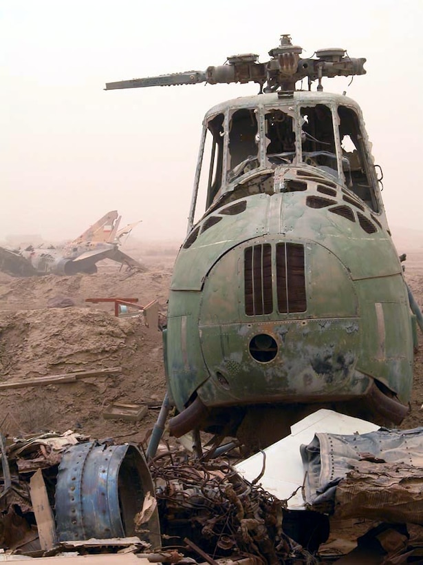 OPERATION IRAQI FREEDOM (AFPN) -- The wreckage of an Iraqi air force helicopter and jet sit amid the debris of an aircraft bone yard on Tallil Air Base in southern Iraq.  Many of the wrecked aircraft, which had been destroyed during Operation Desert Storm in 1991, were pushed onto the base's runway in an effort to keep coalition forces from using the field.  Since taking the air base in late March, most of the debris and wreckage has been removed and active air operations are running 24 hours.  (U.S. Air Force photo by Bob Jensen)