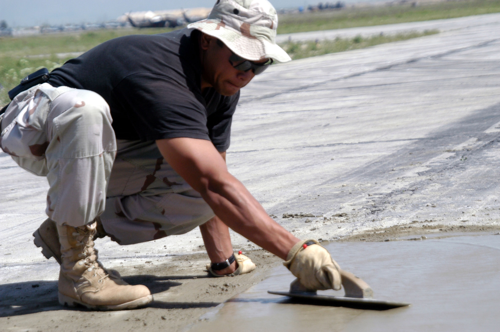 OPERATION ENDURING FREEDOM (AFPN) -- Staff Sgt. Stephen Deen smoothes concrete on the active runway at Bagram Air Base, Afghanistan, as part of a $2.3 million airfield repair project.  Deen is a pavements and equipment operator with the 455th Expeditionary Operations Group civil engineer element. He is deployed from the 30th Civil Engineer Squadron at Vandenberg Air Force Base, Calif.  (U.S. Air Force photo by Tech. Sgt. Adam Johnston)