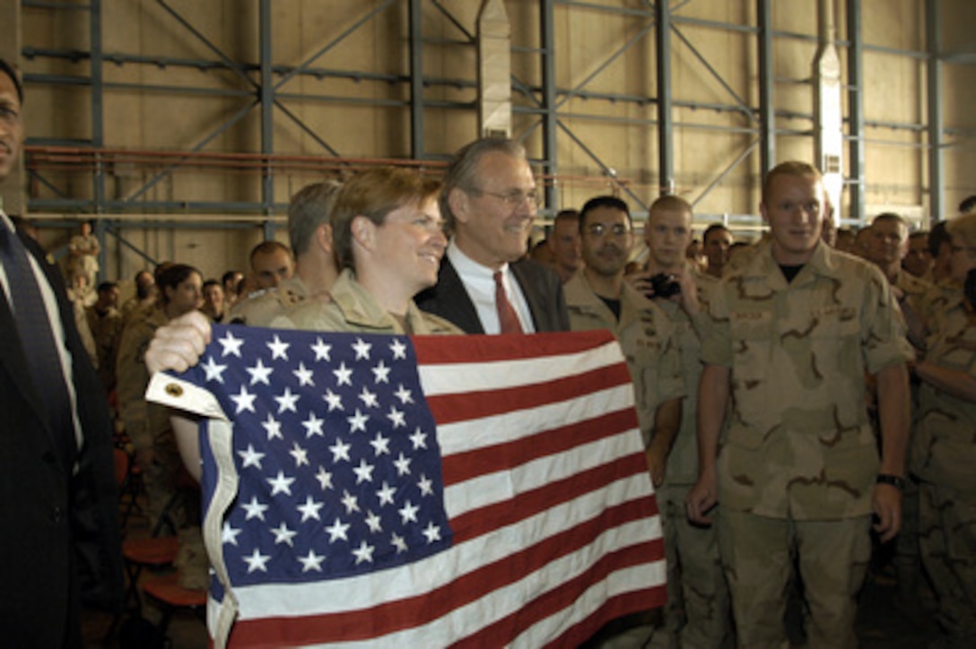 Secretary of Defense Donald H. Rumsfeld poses for a photograph with Navy Petty Officer 1st Class Lauren Fyfe, of Raleigh, N.C., following a town hall meeting at Prince Sultan Air Base, Saudi Arabia, on April 29, 2003. Rumsfeld addressed the troops and then took questions from the military audience. Rumsfeld is visiting the troops and senior leadership in the Persian Gulf region. 
