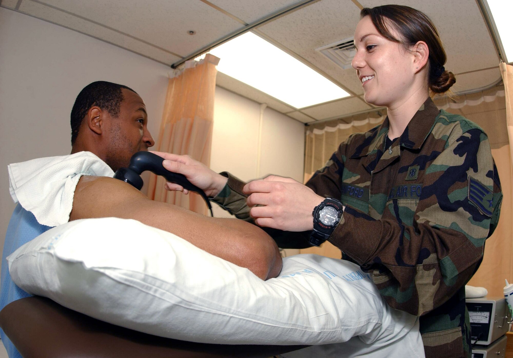 YOKOTA AIR BASE, Japan -- Staff Sgt Shizuka Sanford uses ultrasound equipment to treat Tech. Sgt. Jeff Fant's shoulder.  Sanford is a physical therapy technician from the 374th Medical Group here.  The physical therapy element provides services that help restore function, improve mobility, relieve pain and prevent or limit disabilities of thousands of patients each year. (U.S. Air Force photo by Master Sgt. Val Gempis)