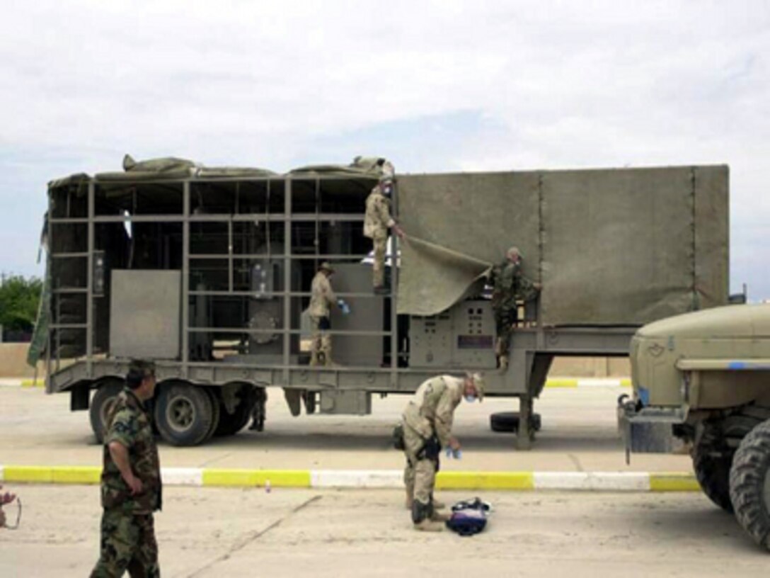 Members of a mobile exploitation team examine a suspected mobile biological weapons facility that was recovered by U.S. Forces in northern Iraq in late April. The trailer resembles one of the mobile laboratories described by Secretary of State Colin Powell in his remarks to the United Nations Security Council in February. 