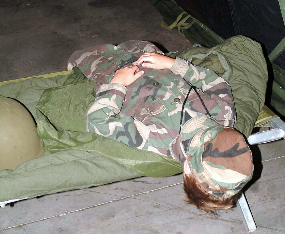 TINKER AIR FORCE BASE, Okla. -- Joseph Brown takes a break from the rigors of living on "Base X."  He is the son of Tech. Sgt. John Brown from the 72nd Security Forces Squadron here.  Joseph and other children of airmen assigned here participated in Operation KUDOS, designed to help "Kids Understand Deployment Operations."  They received briefings, processed through a deployment line, received ID cards and dog tags.  At "Base X," they received samples of meals ready to eat and toured through tents that house sleeping quarters, kitchens and recreation areas.  (U.S. Air Force photo by Airman K.L. Kimbrell)