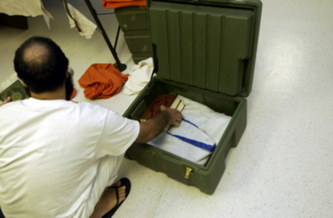 A detainee packs his personal belongings prior to being relocated to a medium security facility at Guantanamo Bay, Cuba, providing a communal living environment allowing greater freedom of movement and group recreation. 