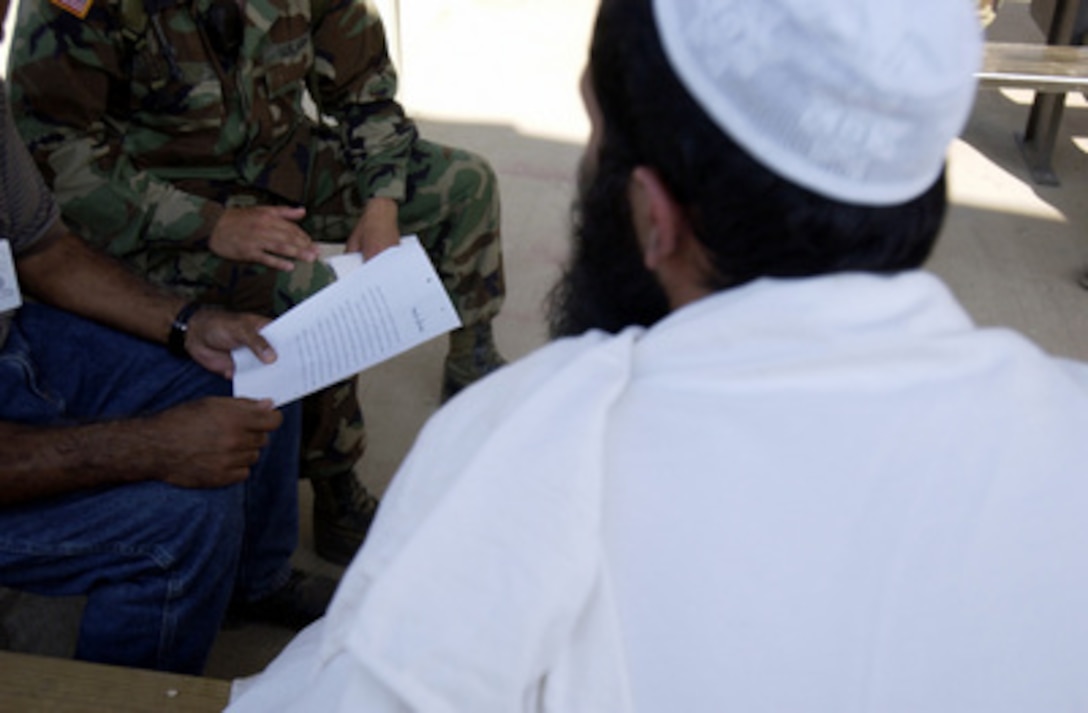 The detainee leader for a medium security facility is read the camp rules. It will be his job to relay those rules to other detainees that will occupy his bay within a communal living environment allowing greater freedom of movement and group recreation. 