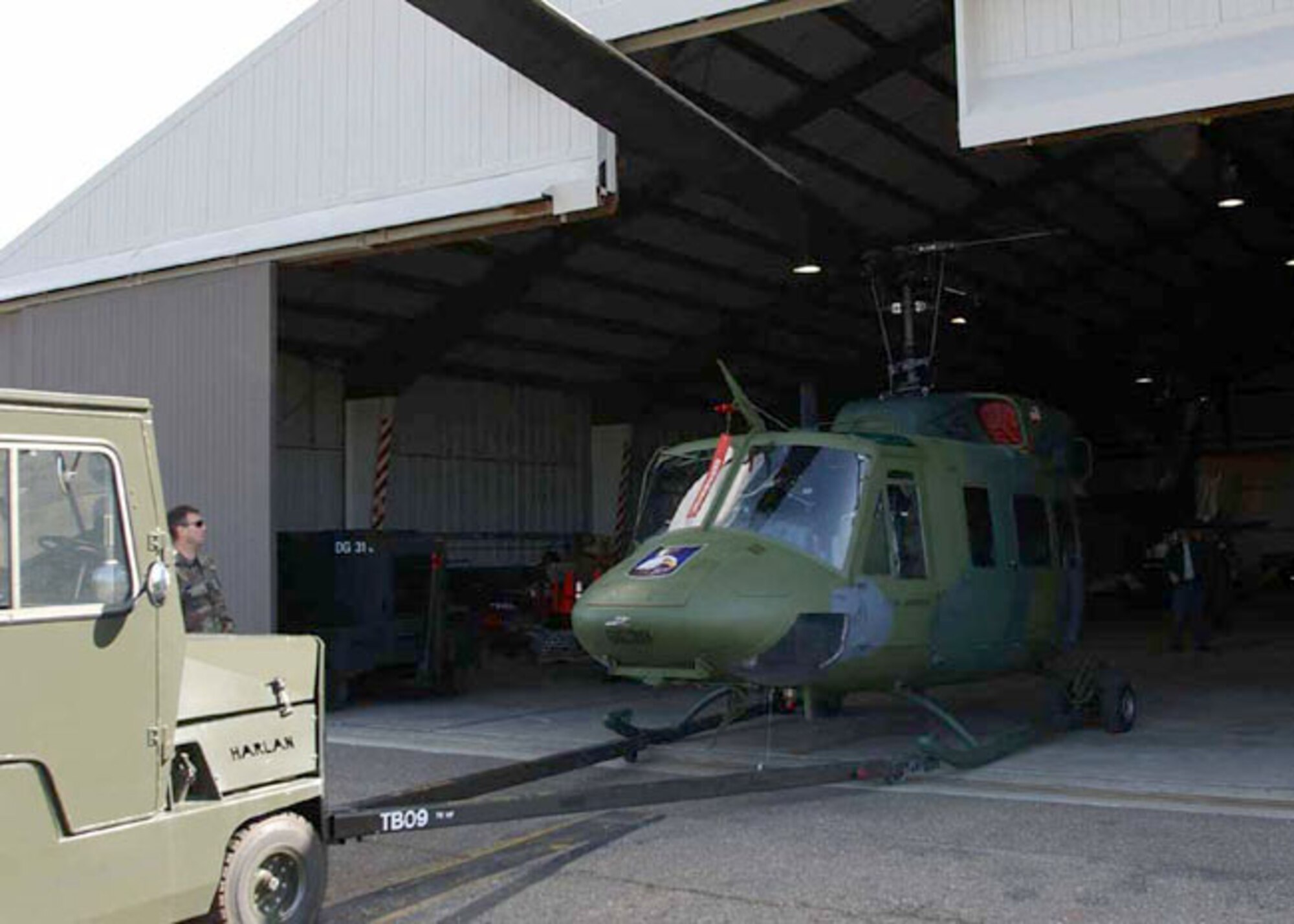 VANDENBERG AIR FORCE BASE, Calif. -- A helicopter is pushed into the newly modified hangar for the 76th Helicopter Flight.  Previously, base officials here rented a 20,000 tent for the aircraft during the annual Guardian Challenge competition.  (U.S. Air Force photo by Senior Airman Jonathan Pomeroy)