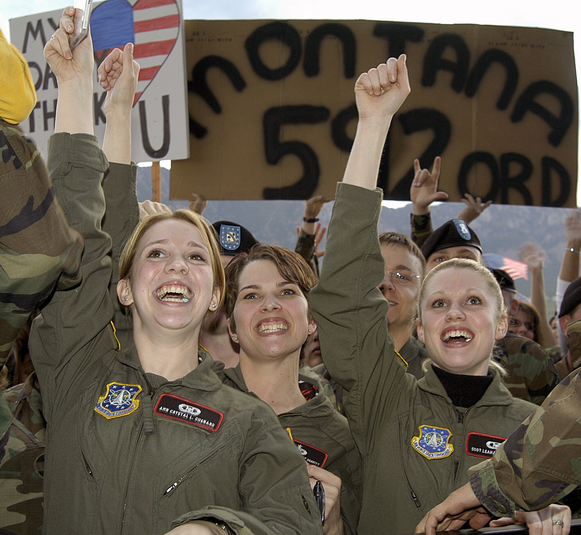 FORT CARSON, Colo. (AFPN) -- Left to right: Airman Crystal Chenard and Staff Sgts. Christy Gravitt and Leahanna Neas, all from the 21st Space Wing Operations Center at Peterson Air Force Base, Colo., cheer during a free concert for military and family members here May 21.  He put on the free concert to show appreciation for the military.  (U.S. Air Force photo by Budd Butcher)